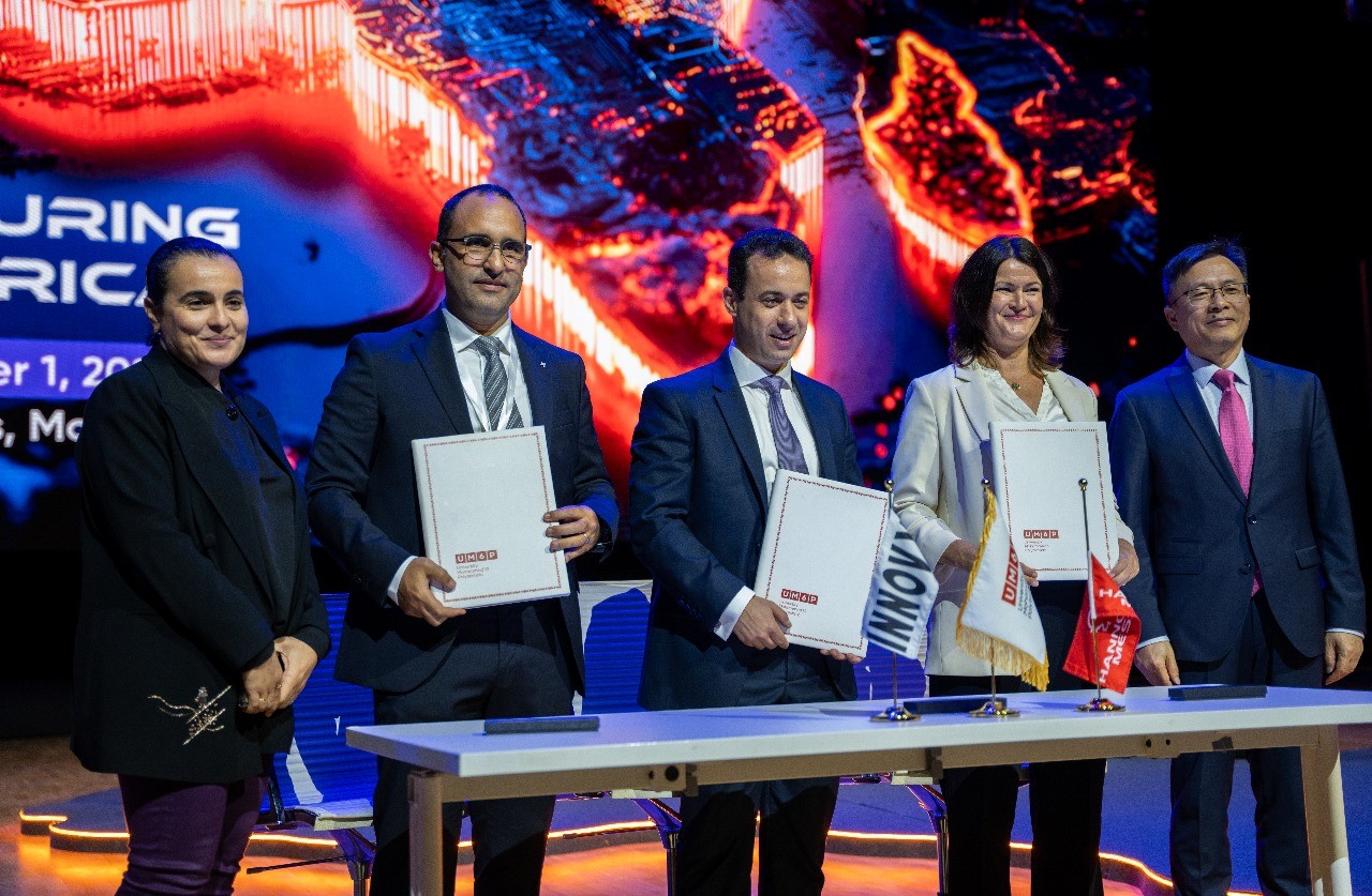 Drei Männer und zwei Frauen, die ein Schriftstück hochalten, bei der Unterzeichnungszeremonie der Industrial Transformation Africa 